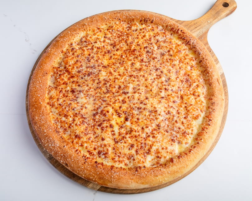 A whole cheese pizza with a golden crust, sprinkled with parmesan, on a wooden serving board.