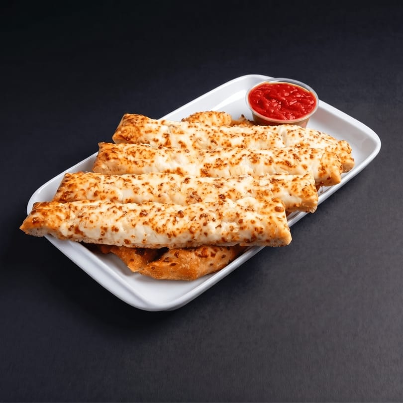 Cheesy breadsticks with a side of marinara sauce on a white rectangular plate.