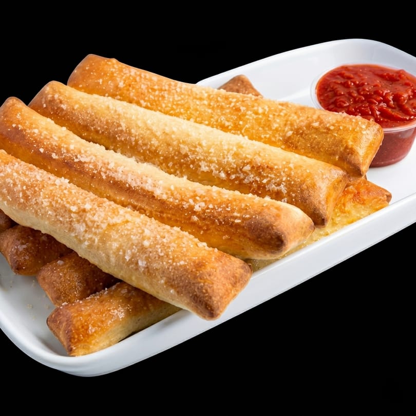 Golden-brown breadsticks sprinkled with Parmesan cheese, served with a side of marinara sauce.