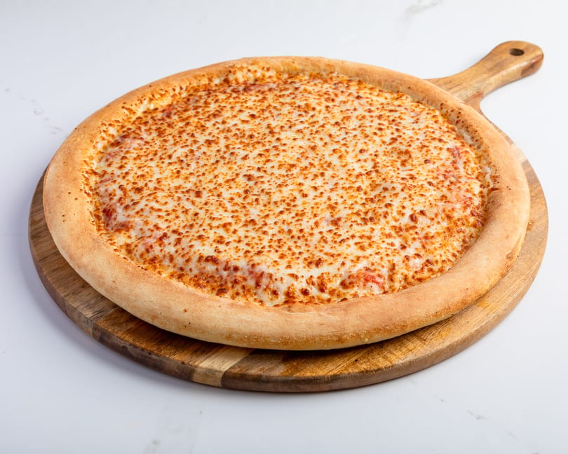 A large, round cheese pizza with a golden crust sits on a wooden serving board.